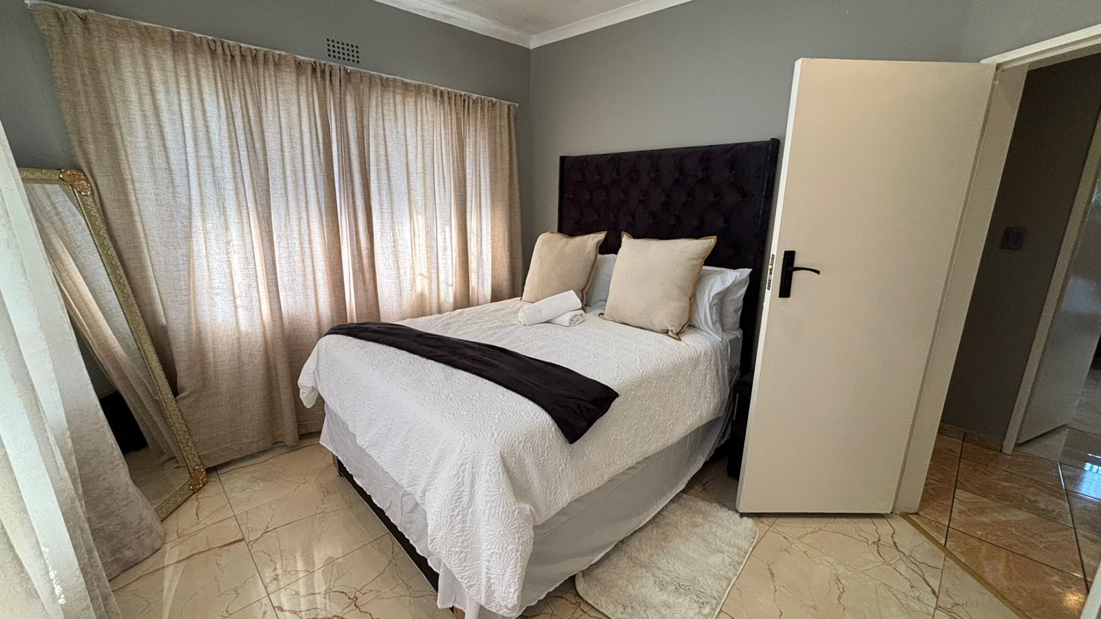 Bedroom suite with white bedding and soft curtains