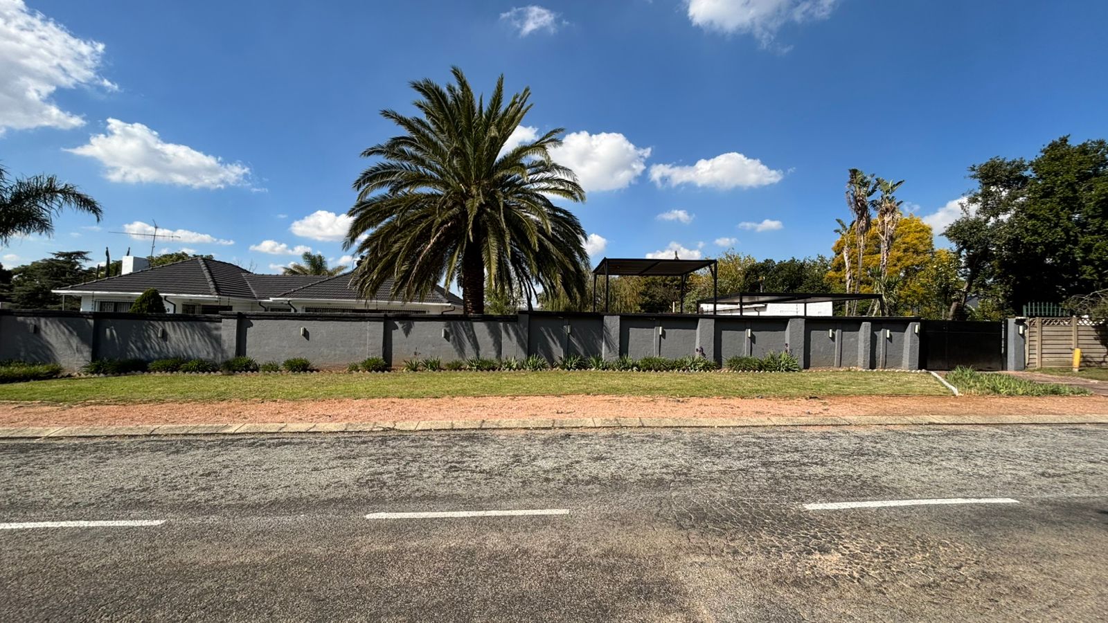 Bella Vista exterior from the street with a gray boundary wall