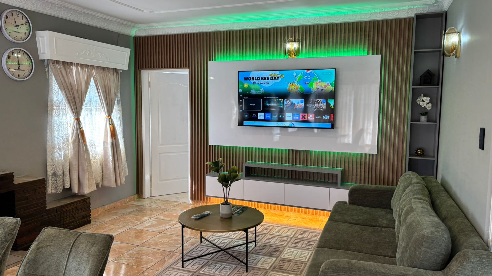 Living room with television wall and green feature lighting